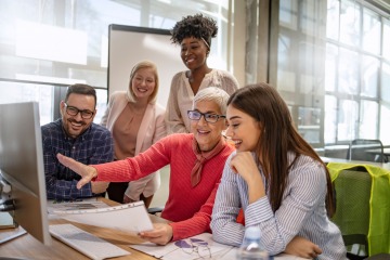 group of individuals collaborating behind a computer screen